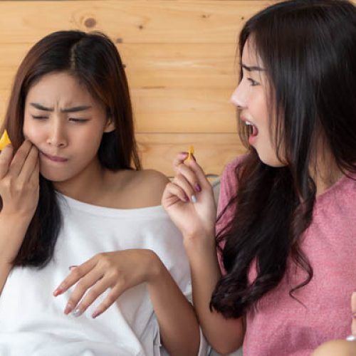 woman suffering from tooth sensivity, tooth decay or food stucking between teeth or gum; dental care concept